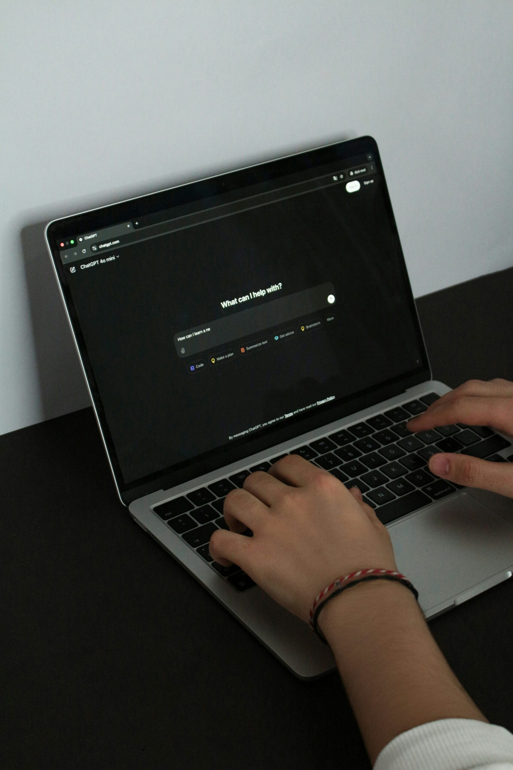 A person typing on a laptop on a table